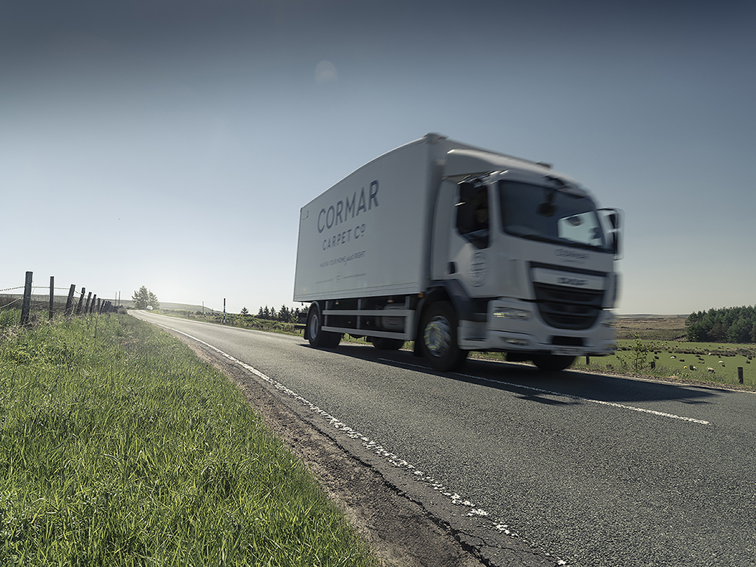 Cormar Carpets truck driving down the road towards the camera